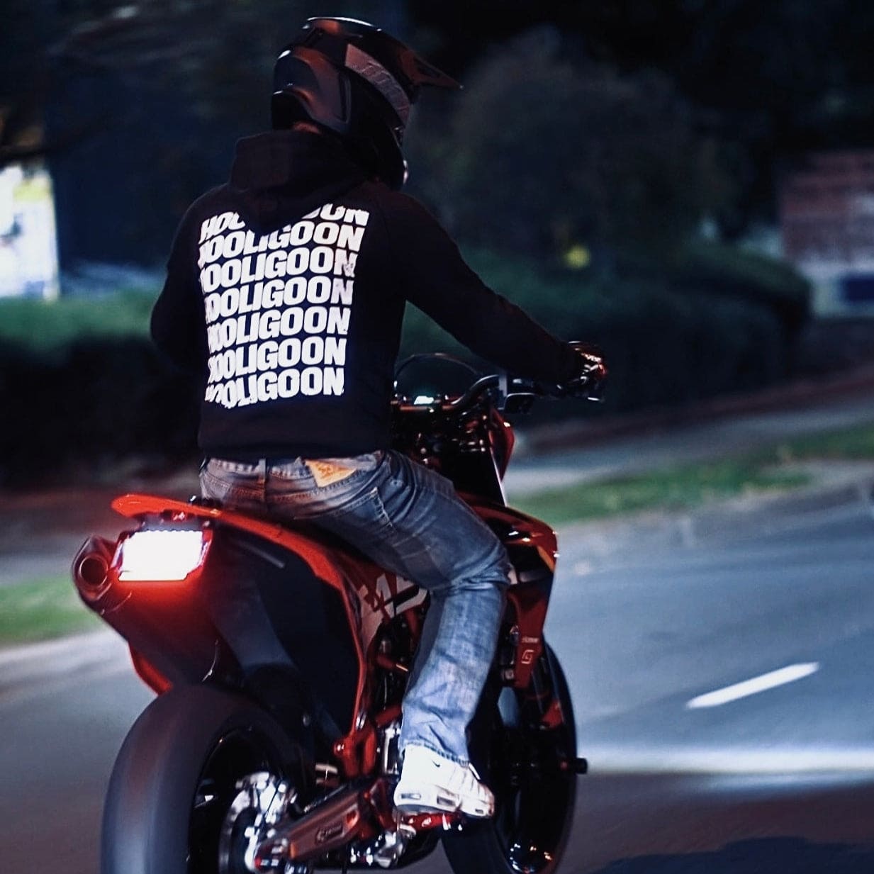 Person riding a motorcycle at night with a dark background