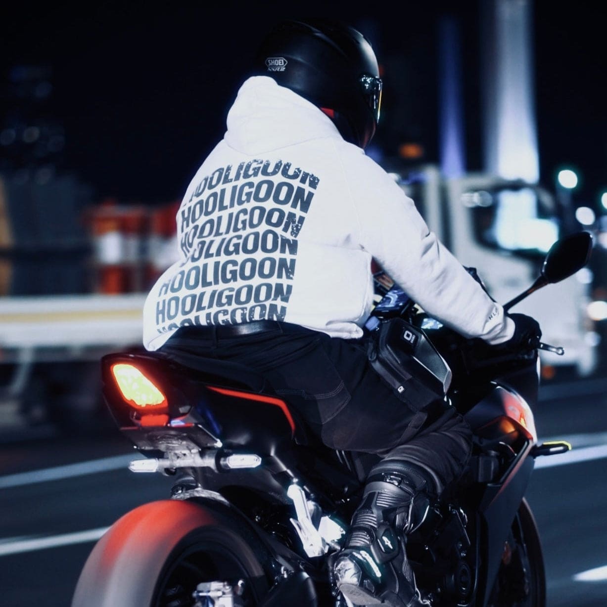Person riding a motorcycle at night with a dark background