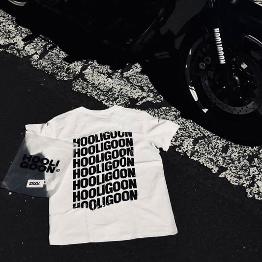 White t-shirt with 'Hooligoon' text in front of a black motorcycle on a dark background