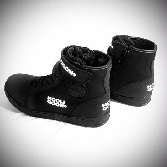 Pair of black high-top sneakers with visible branding on a light gray background