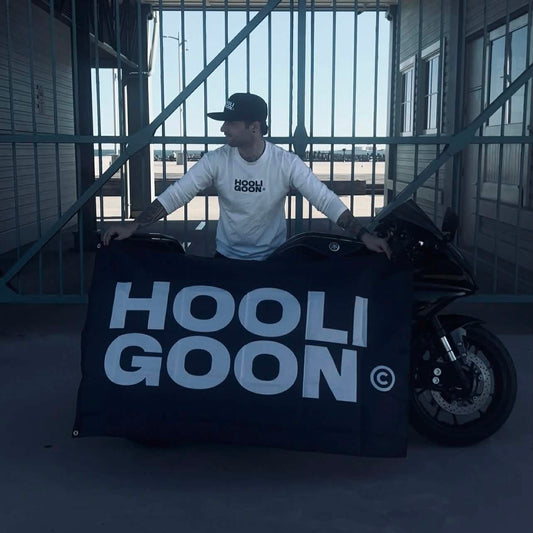 Person sitting on a motorcycle with 'Hooligoon' branding in an indoor setting