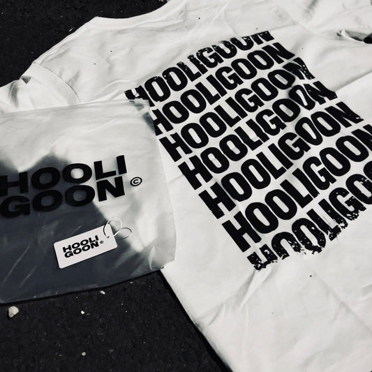 White t-shirt with 'HOOLIGOON' text and packaging on a dark surface