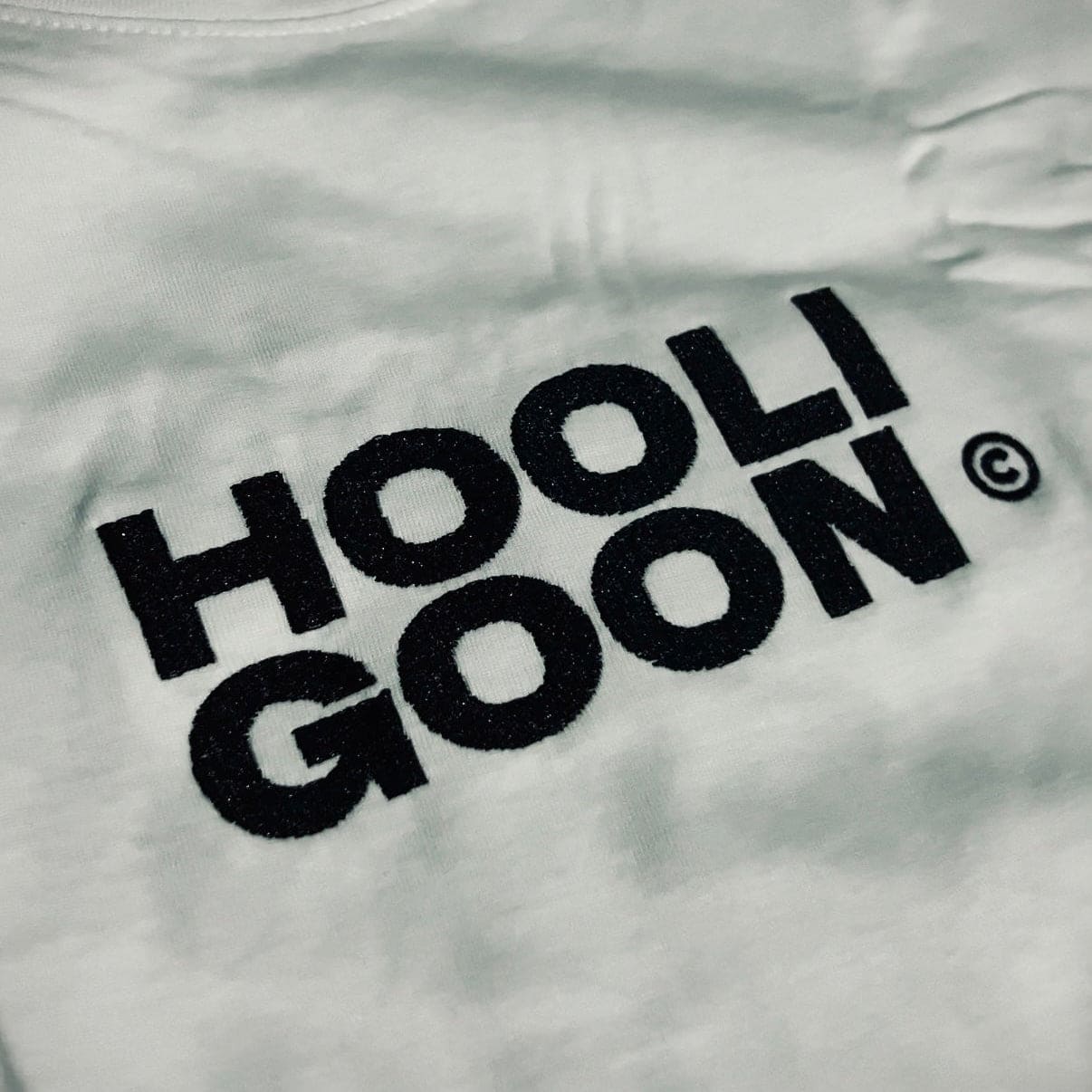 White shirt with 'HOOLIGOON' text on a plain background