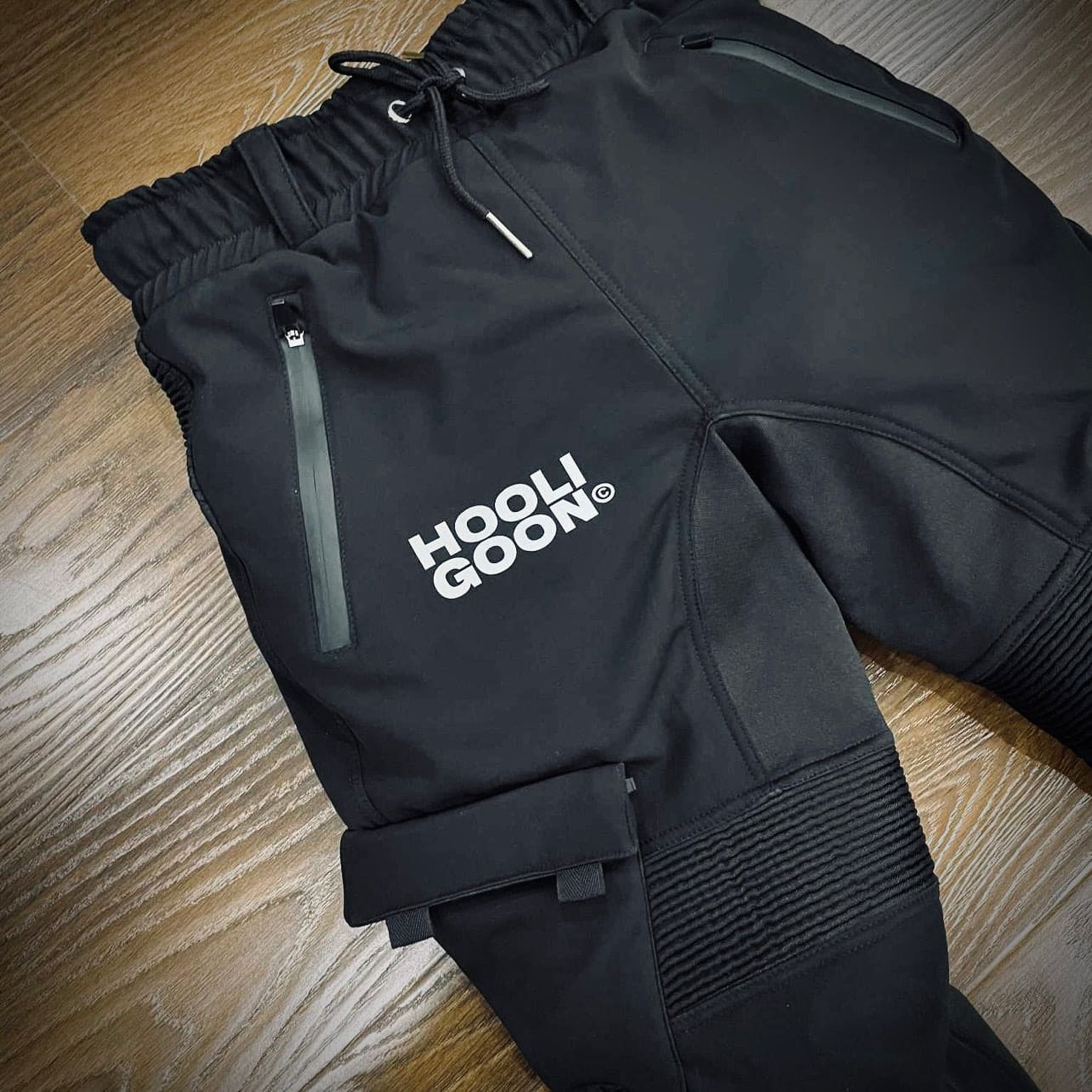 Black tracksuit with 'HOOLIGOON' logo on a wooden floor