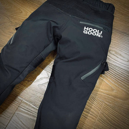 Black pants with 'Hooligoon' logo on a wooden floor