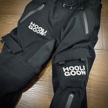 Black pants with 'Hooligoon' branding on a wooden surface