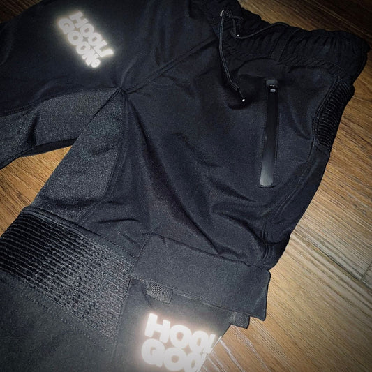 Black tracksuit with reflective accents on a wooden floor